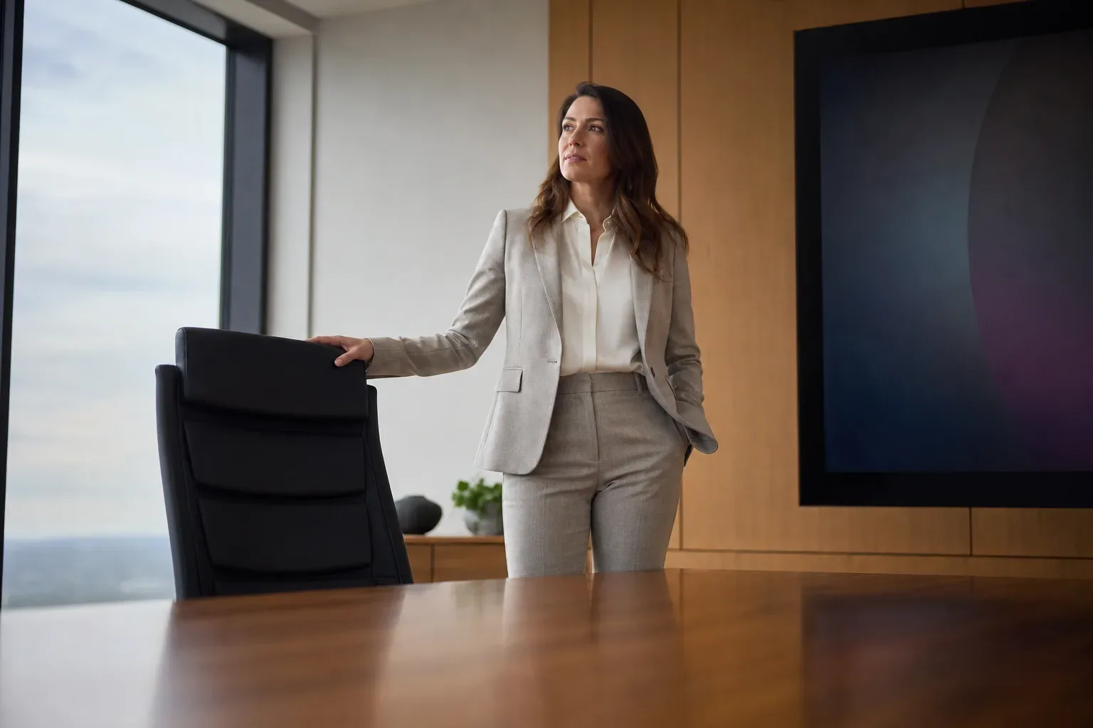 A high-backed boardroom chair at a polished table
