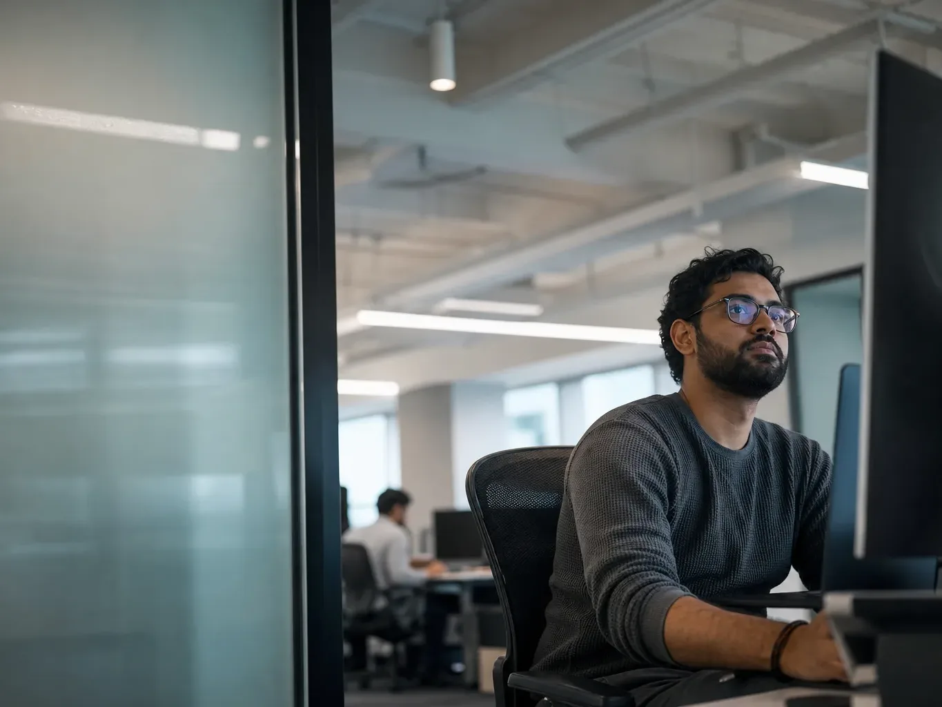A frosted glass partition beside a data team area
