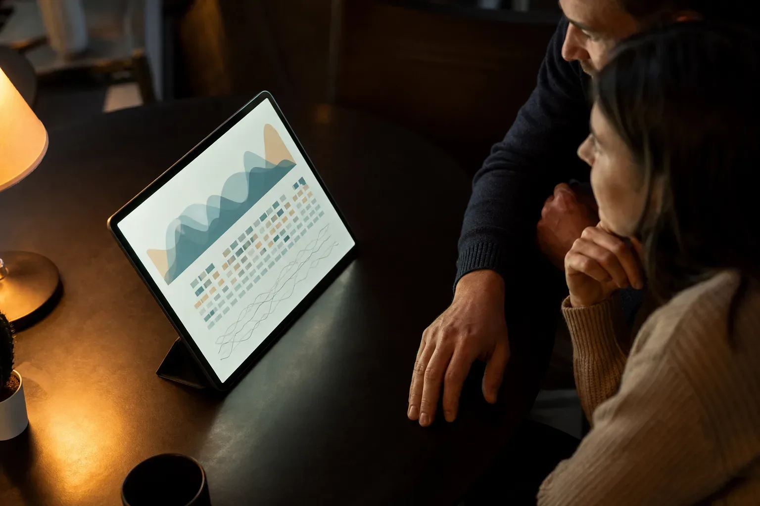 A tablet propped upright showing an abstract unreadable data visualisation